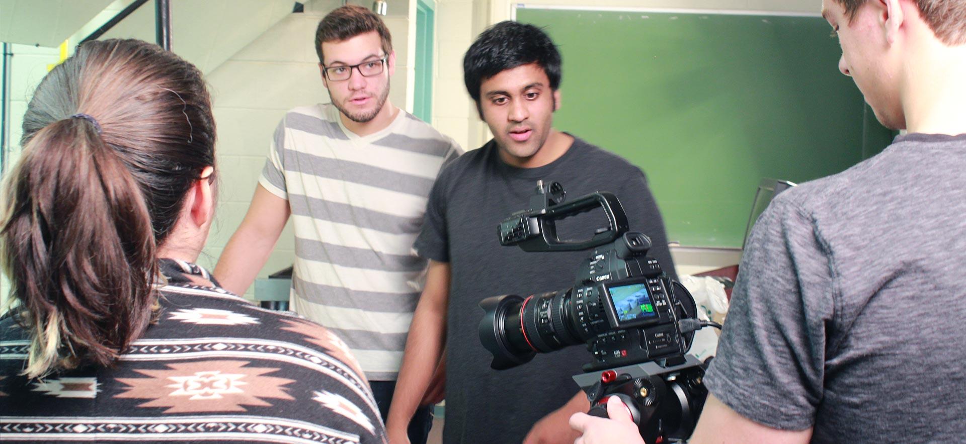 Digital video students prepare to shoot a video on the о campus.